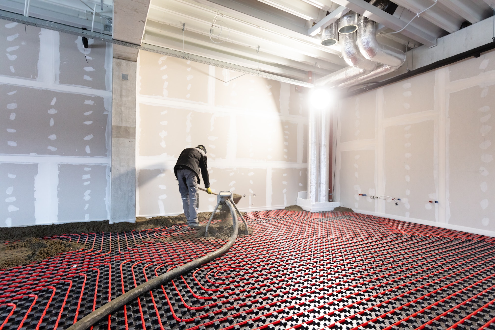 Worker installing floor heating in a new building
